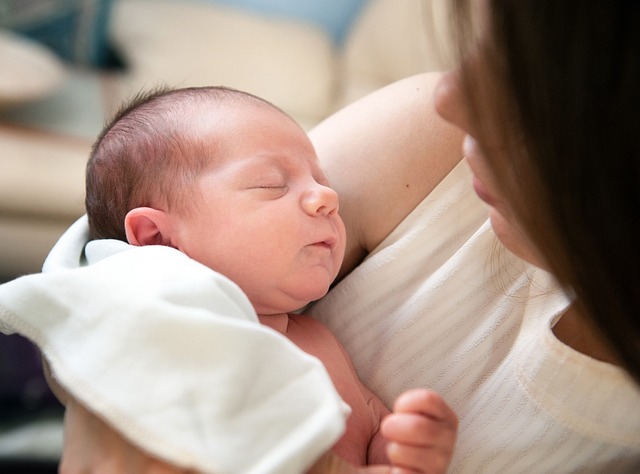 A mum cradles a newborn baby in her arms