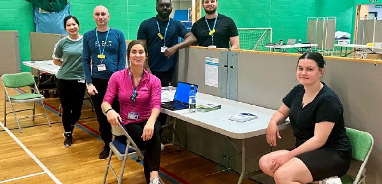 staff sat at a table in a gym